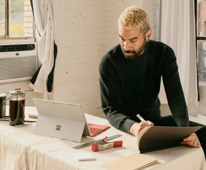 A man doing some computer work on his tablet